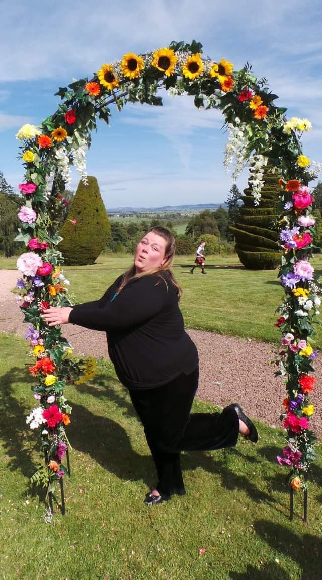 Jan shows her hilarious personality while pouting under a floral ceremonial arch in the grounds of Fingask