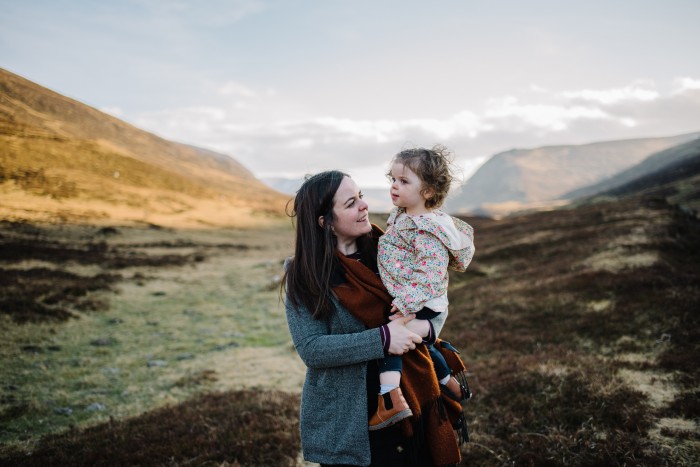 Wedding photographer Ruth Segaud stands in Highland Perthshire holding her baby daughter.
