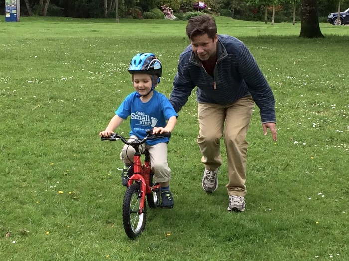 Dad proudly stands behind giving James an encouraging push to get him pedalling!