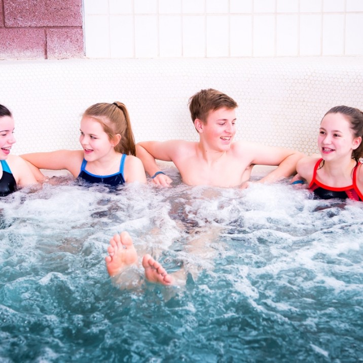 Teenagers having a gossip in the huge Jacuzzi bath at the Leisure Pool.